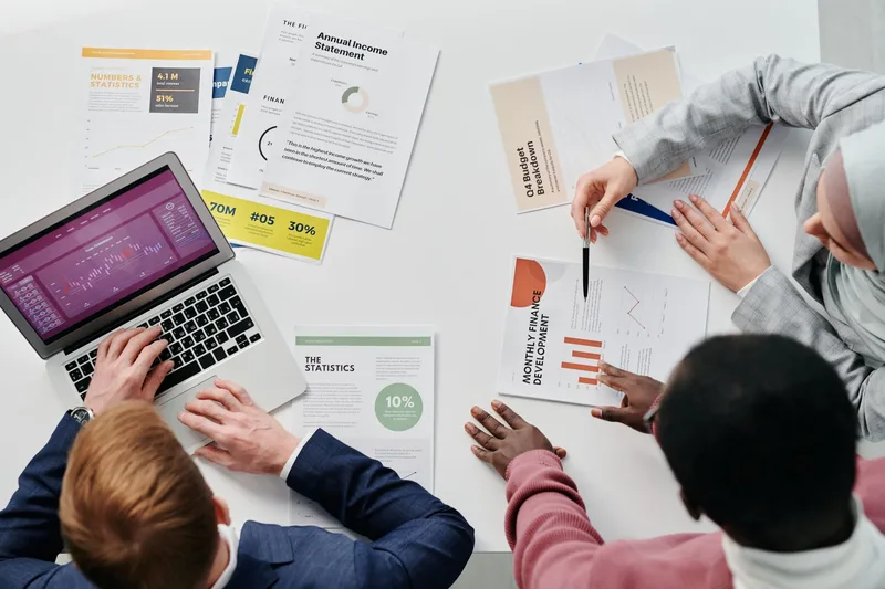 Business meeting with professionals discussing financial reports and graphs at a work desk