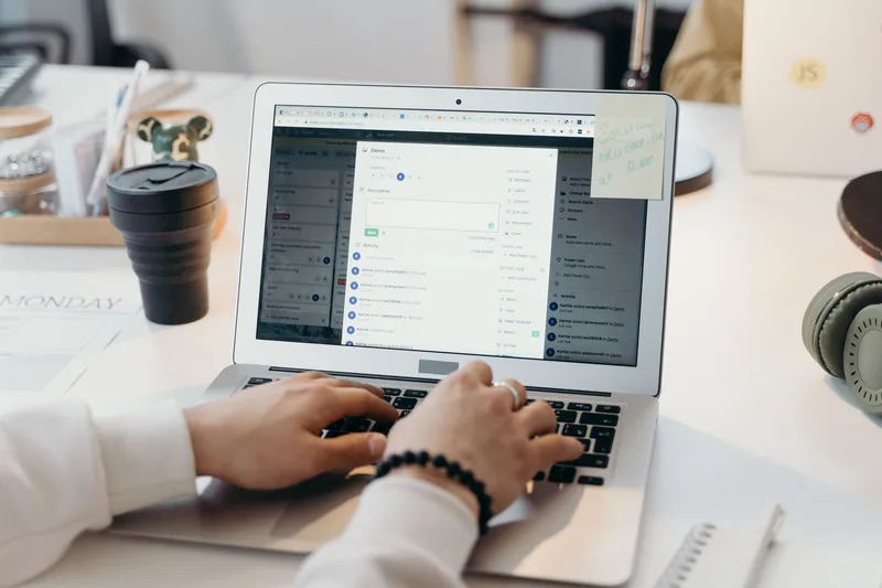 Person typing on a laptop in a bright office, representing the plugin setup work involved in editing WooCommerce email templates