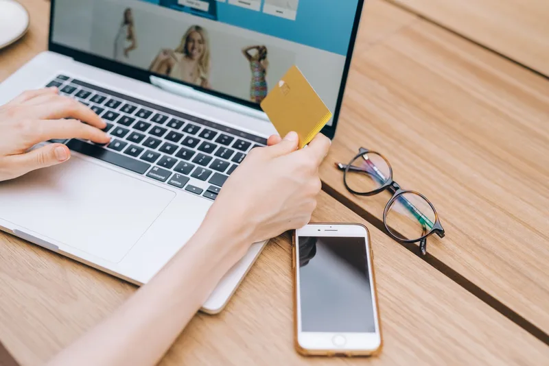 Shopper completing an online purchase with a credit card on a laptop, representing a dropshipping store checkout conversion