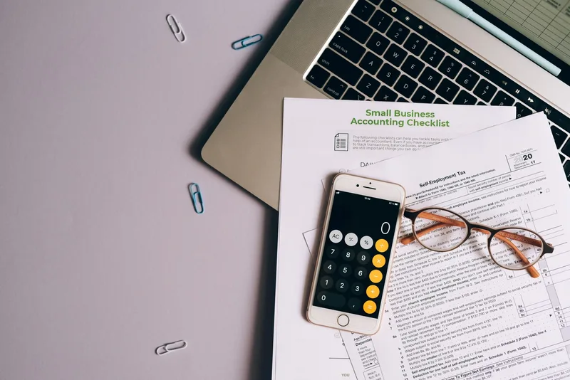 Small business budget planning with documents and phone, representing daily campaign budget decisions for Lazada Ads