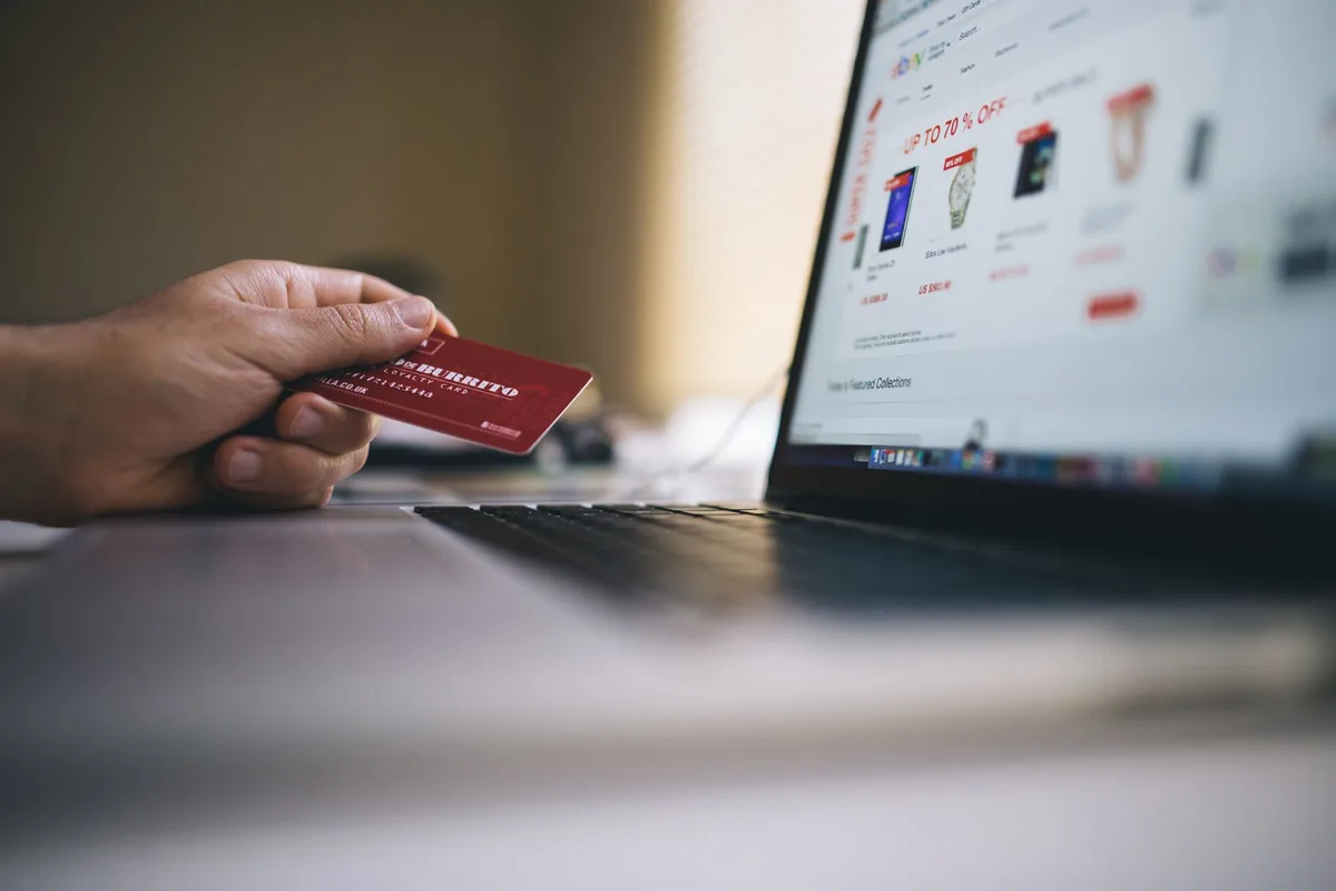 Person holding credit card and shopping online on a laptop, representing UAE ecommerce activity