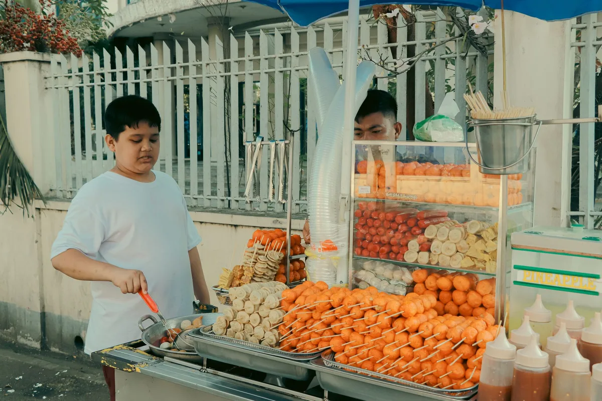 Filipino ecommerce seller managing TikTok Shop live selling session on a smartphone with packaged products in the background